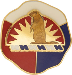 gold metal pin with a brown bear in the middle and white, red and blue on the background