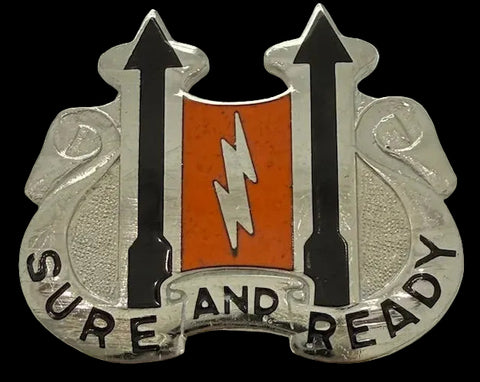 Metal pin with arrows, a lightning bolt, and 'SURE AND READY' text on a textured background