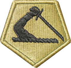 Hexagonal patch with black embroidered design on a beige background