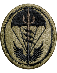 Circular military patch with a design of a parachute and wings on a beige background
