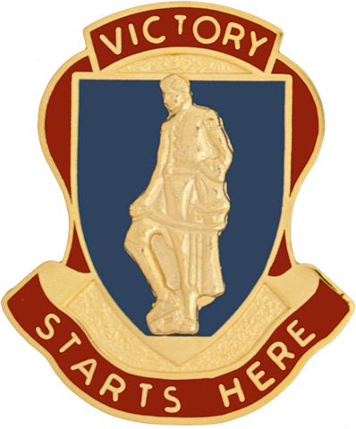 Uniform unit crest in metal with a statue and 'Victory Starts Here' text on a blue and red background